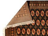 an image of a black rug with a red and gold design on it