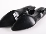 pair of black leather shoes on a white surface with a white background