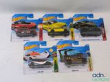 five hot wheels cars on display on the table