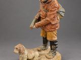figurine of a man with a dog on a wooden base