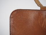 brown leather case with a wooden handle on a white surface