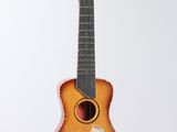 an old wooden guitar hanging from a string on a white wall