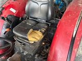 a red tractor that is parked in a garage