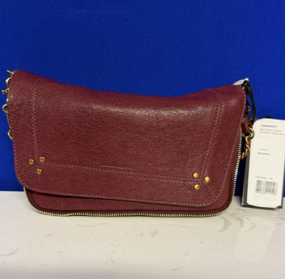 un sac à main en cuir rouge orné de finitions dorées sur le devant et sur le côté