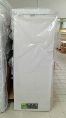 Des cartons contenant des matelas sont empilés les uns sur les autres dans un entrepôt