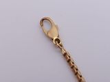 a close up of a gold chain with a clasp on a white surface