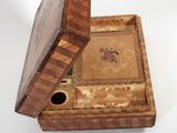 a small wooden box with a lid on a white surface
