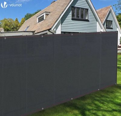 a black privacy fence in front of a house