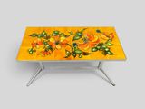 une table jaune sur laquelle sont peintes des fleurs