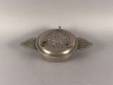 an antique silver plate with a decorative design on it