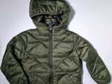 La veste est verte et possède une capuche.