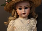 a doll that is wearing a hat with flowers on it