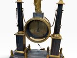 a clock that has a statue on top of it