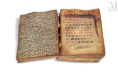 an old book with chinese writing is open on a white surface