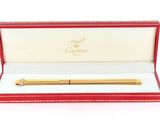 une image représentant un stylo doré dans un coffret rouge posé sur un fond blanc
