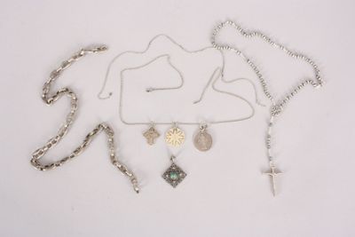 a lot of necklaces and a cross on a white surface