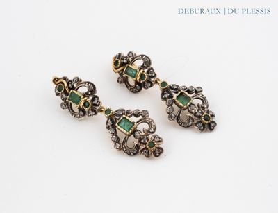 a pair of emerald and diamond earrings on a white surface