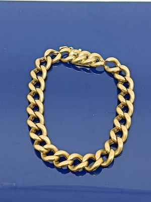 une image représentant un bracelet en or sur un fond bleu