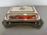 a silver plate with a glass lid on a table