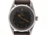 montre-bracelet avec cadran noir et bracelet en cuir marron sur fond blanc