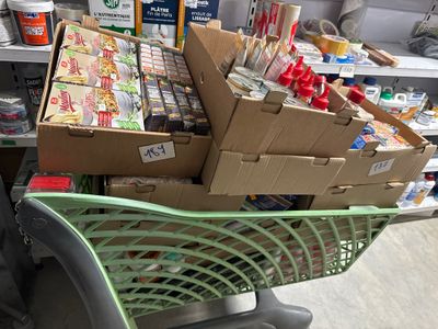 de nombreuses boîtes de nourriture dans un caddie au supermarché