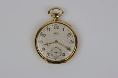 une montre de poche en or sur une surface blanche