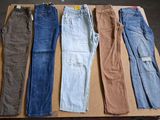 five pairs of men ' s jeans sitting on top of a cardboard box
