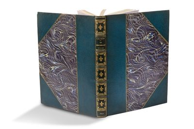un livre bleu aux bords dorés, avec un motif décoratif sur la couverture