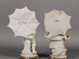 two figurines of people holding umbrellas on a table
