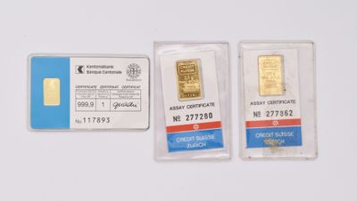 two gold bars are sitting next to each other on a white surface