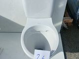 a white toilet sitting on a table with a price tag