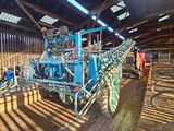 a man that is standing next to a machine in a barn