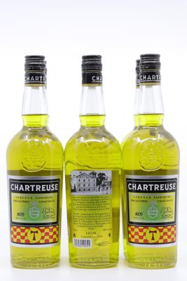 trois bouteilles de Chartreuse sont alignées sur une surface blanche