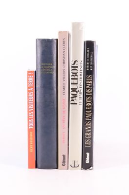 plusieurs livres sont empilés sur une surface blanche