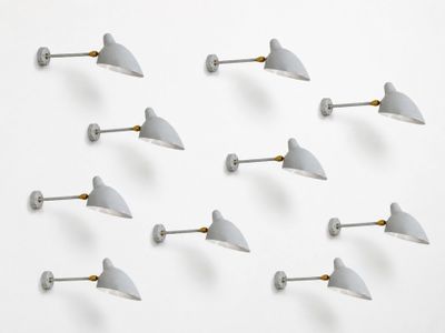 six white wall lights are arranged in a row on a white surface