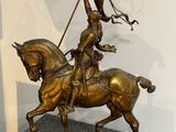 statue en bronze représentant un homme à cheval tenant un drapeau