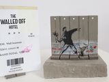 a statue of a man holding a gun next to a hotel sign