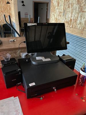une table rouge sur laquelle sont posés un écran et une imprimante