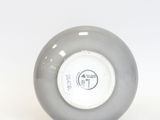 a gray ball with a white top sitting on a white surface