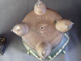 four birds sitting on top of a vase on a table