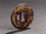 a small round metal object with a design on it