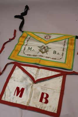 deux tabliers portant des lettres, posés sur une table