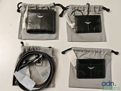 three black leather wallets are sitting on top of a white table