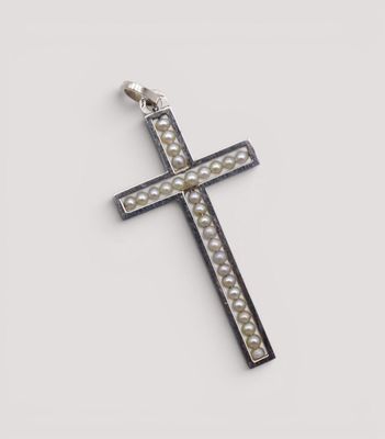un gros plan d'une croix sur une surface blanche