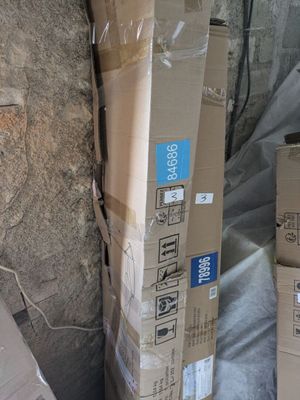 une pile de cartons posée par terre près d'un mur