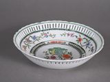 a white bowl with green and red designs on it