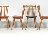 trois chaises en bois assises l'une à côté de l'autre sur une surface blanche