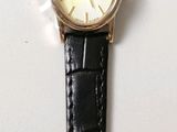a watch with a bird on it hanging on a wall