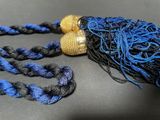 a blue and black tassel with a gold bead on it