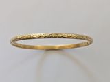gros plan d'une bague en or sur une surface blanche